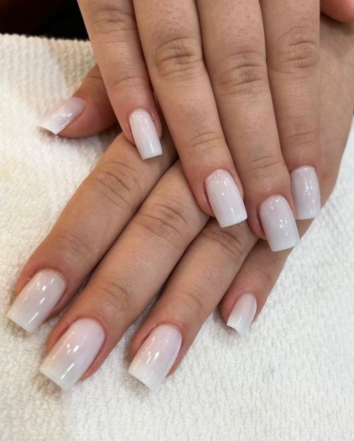 Unhas brancas decoradas com efeito marmorizado.