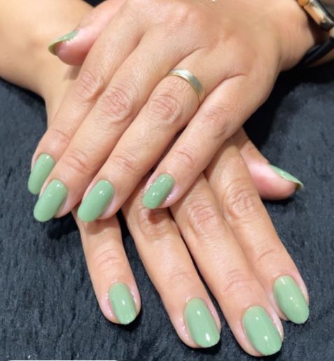 Unhas verdes elegantes com pedrarias discretas