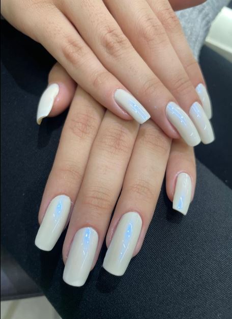 Unhas brancas delicadas com design moderno.