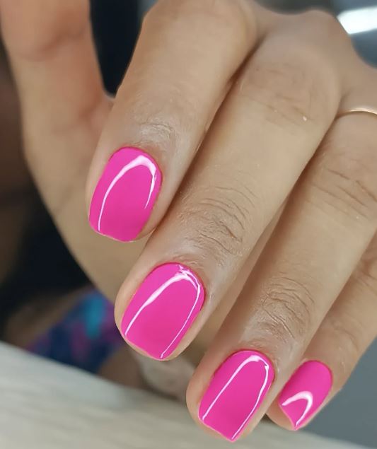 Unhas decoradas rosa com glitter suave.