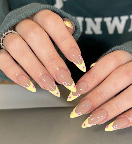 Unhas amarelas com detalhes minimalistas.