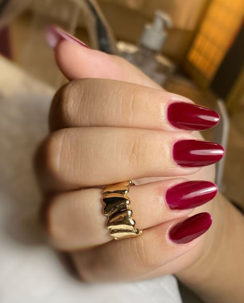 Unhas vermelhas com efeito brilhante.