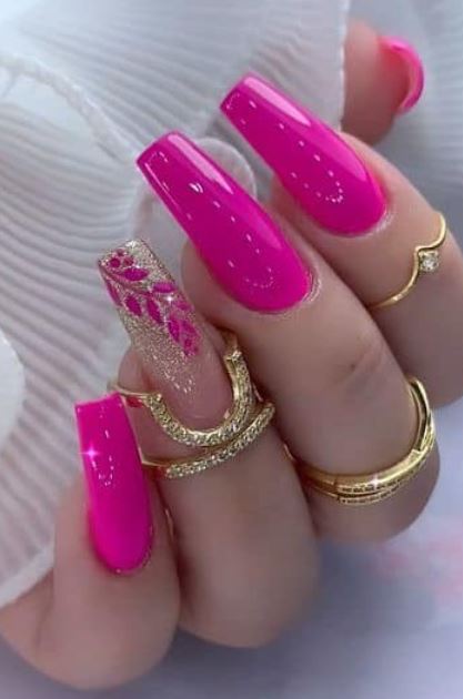 Unhas decoradas rosa com detalhes em branco.