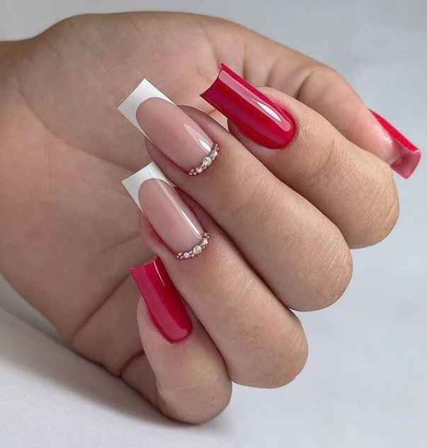 Unhas vermelhas decoradas delicadas.