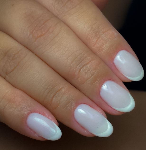 Unhas brancas decoradas com traços minimalistas.