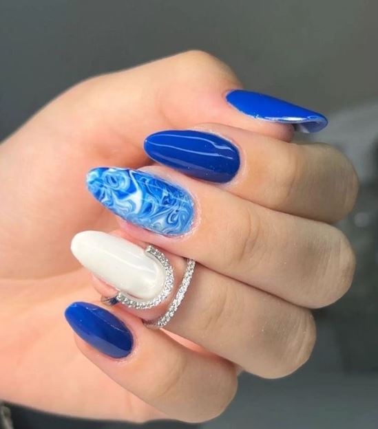 Unhas azuis decoradas com flores delicadas.