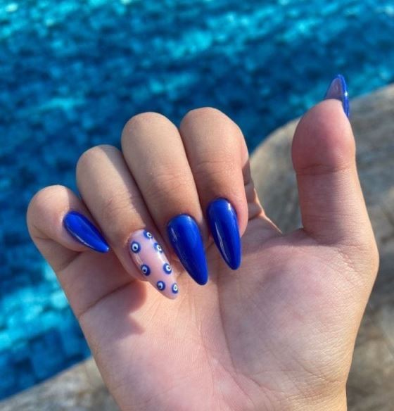 Unhas azul escuro com detalhes dourados.