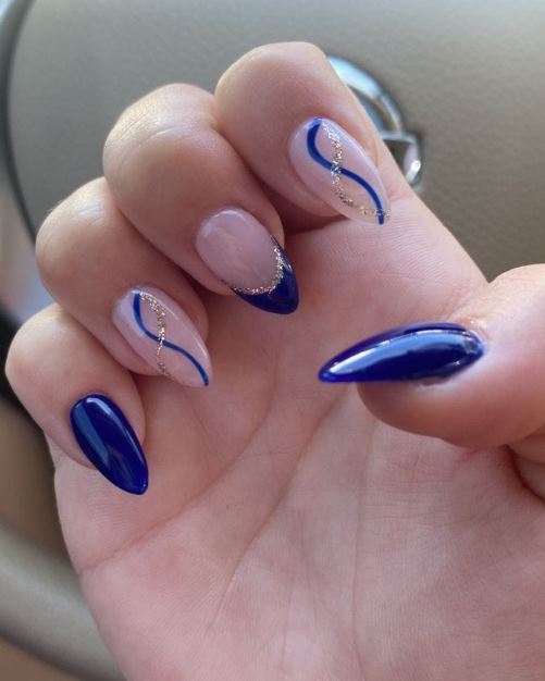 Unhas azuis criativas com nail art geométrica.