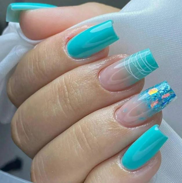 Unhas azul turquesa com decoração tropical.
